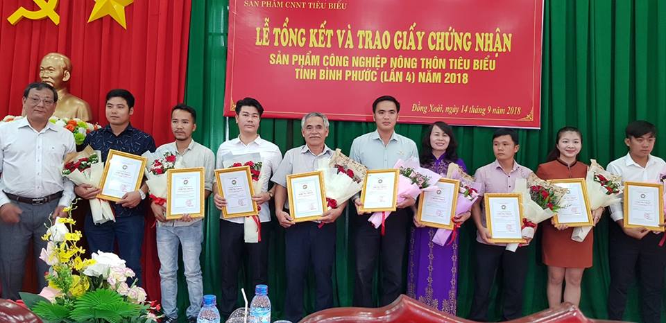 Ông Nguyễn Anh Hoàng - Giám đốc Sở Công thương tỉnh Bình Phước (thứ 1 trái qua) trao giấy chứng nhận sản phẩm công nghiệp nông thôn tiêu biểu khu vực phía Nam năm 2018 cho các doanh nghiệp, cơ sở